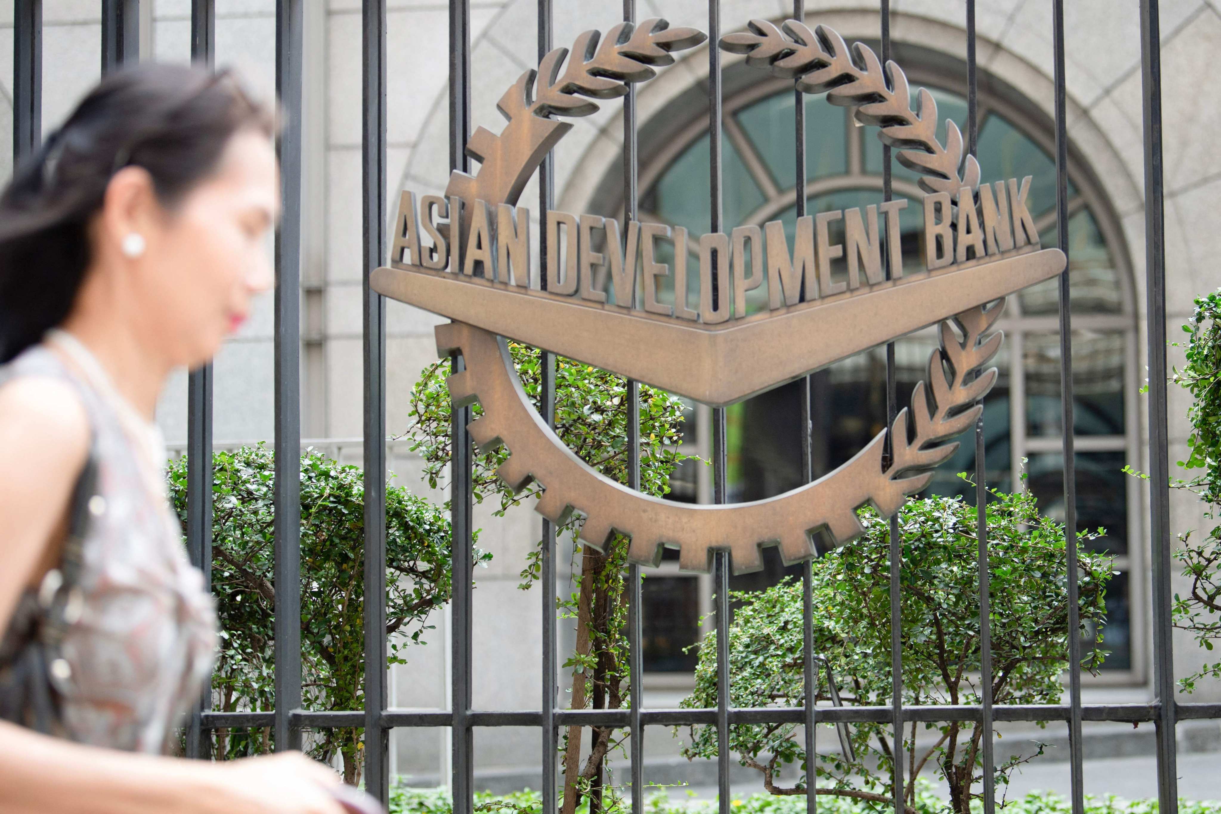 A woman walks past the Asian Development Bank’s headquarters in Manila. Photo: AFP